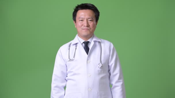 Starší japonský muž lékař proti zeleným pozadím — Stock video