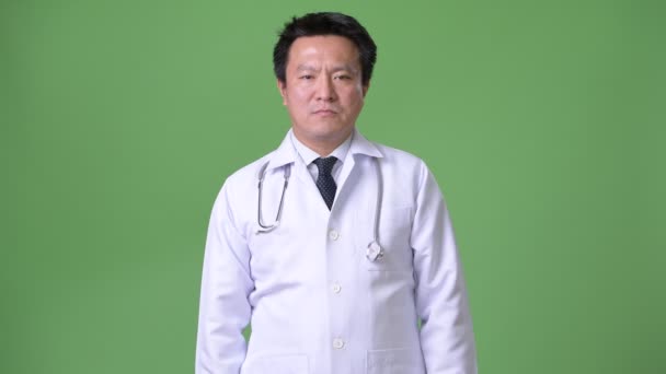 Rijpe Japanse man arts tegen groene achtergrond — Stockvideo