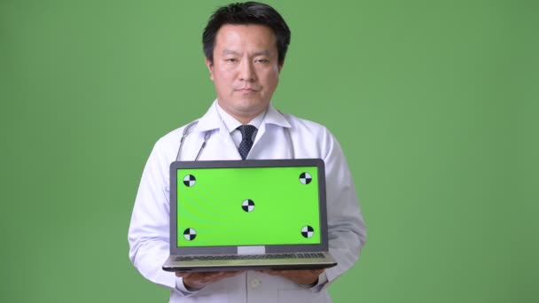Rijpe Japanse man arts tegen groene achtergrond — Stockvideo
