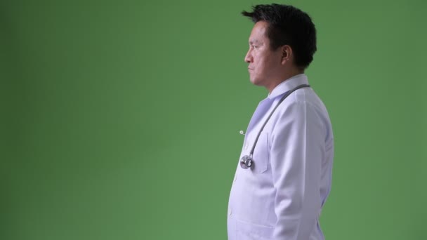 Maduro japonés hombre médico contra verde fondo — Vídeo de stock
