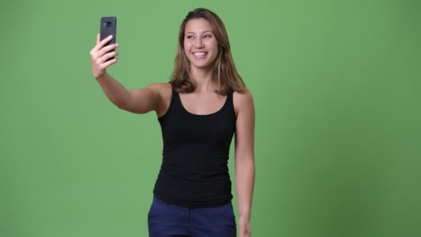 Junge schöne multiethnische Frau vor grünem Hintergrund — Stockvideo