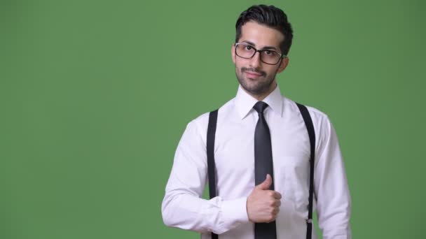 Ung snygg skäggiga persisk affärsman mot grön bakgrund — Stockvideo