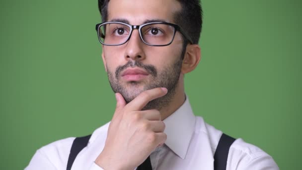 Young handsome bearded Persian businessman against green background — Stock Video