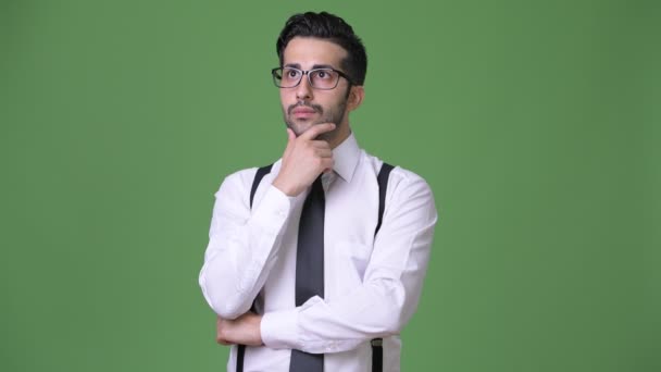 Jonge knappe bebaarde Perzisch zakenman tegen groene achtergrond — Stockvideo