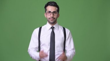Genç yakışıklı sakallı İranlı işadamı yeşil bir arka plana dayanır