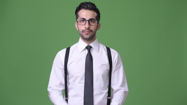 Молодой красивый бородатый персидский бизнесмен на зеленом фоне — стоковое видео