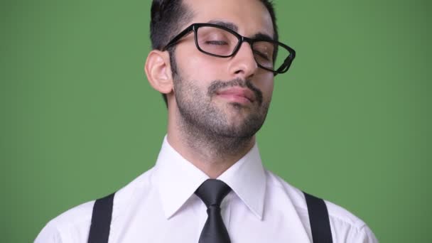 Young handsome bearded Persian businessman against green background — Stock Video