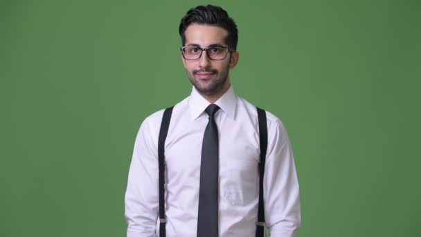 Joven guapo barbudo empresario persa contra fondo verde — Vídeo de stock