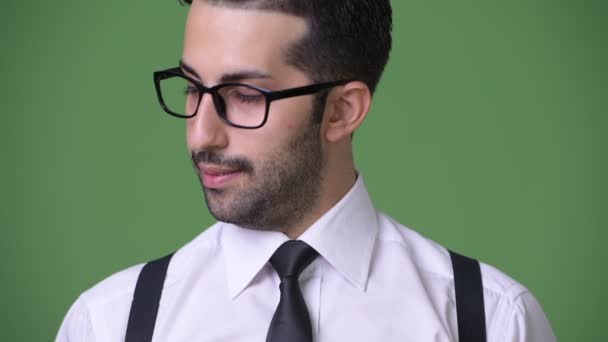 Young handsome bearded Persian businessman against green background — Stock Video