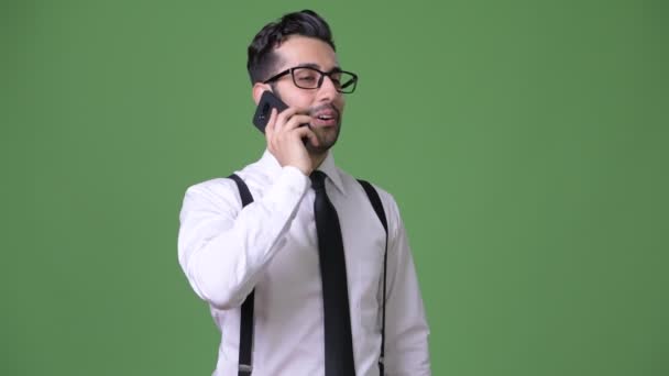Young handsome bearded Persian businessman against green background — Stock Video