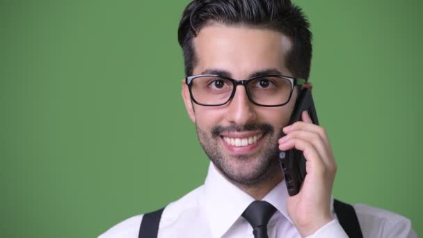 Young handsome bearded Persian businessman against green background — Stock Video