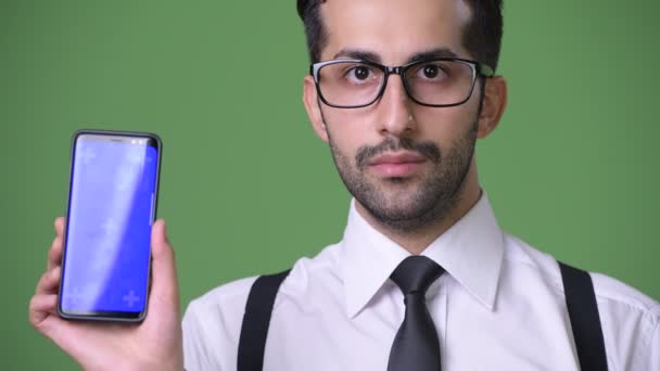 Joven guapo barbudo empresario persa contra fondo verde — Vídeo de stock