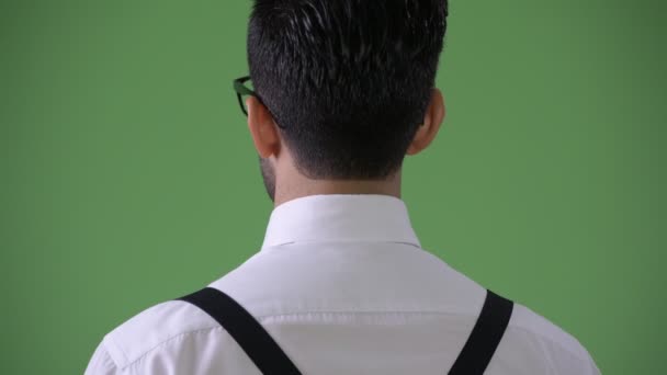 Young handsome bearded Persian businessman against green background — Stock Video