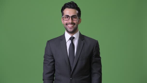 Junger gutaussehender bärtiger persischer Geschäftsmann mit grünem Hintergrund — Stockvideo