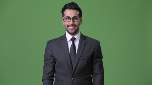 Νέος όμορφος γενειοφόρος Περσικά επιχειρηματίας ενάντια σε πράσινο φόντο — Αρχείο Βίντεο