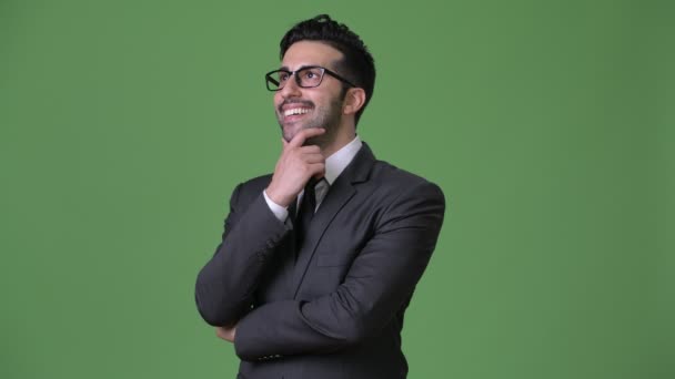 Молодой красивый бородатый персидский бизнесмен на зеленом фоне — стоковое видео