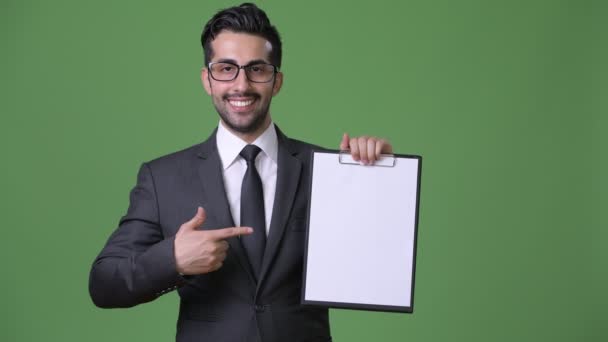 Молодий, красивий бородатий Перська бізнесмен на зеленому тлі — стокове відео