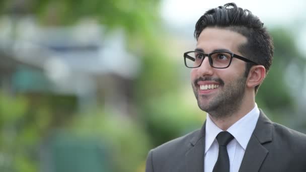 Молодой красивый бородатый персидский бизнесмен на улице — стоковое видео