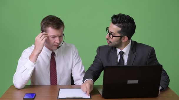 Deux jeunes hommes d'affaires multiethniques travaillant ensemble dans un contexte vert — Video