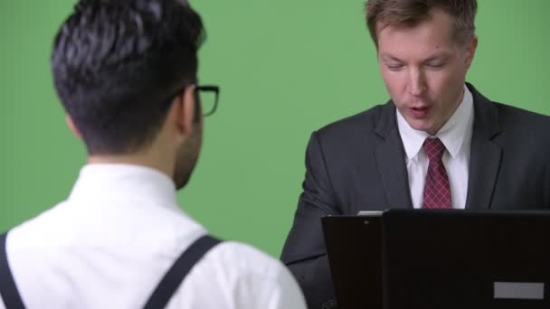 Deux jeunes hommes d'affaires multiethniques travaillant ensemble dans un contexte vert — Video