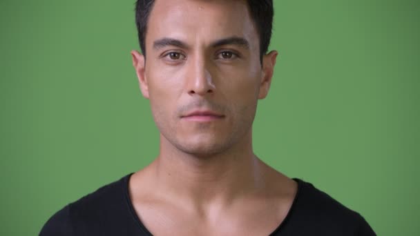 Joven guapo hispano contra fondo verde — Vídeo de stock