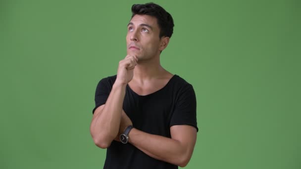 Junger schöner hispanischer Mann vor grünem Hintergrund — Stockvideo