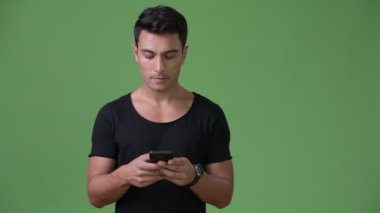 Genç yakışıklı İspanyol adam yeşil bir arka plana dayanır