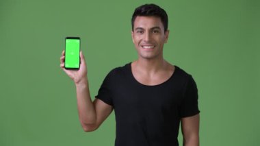 Genç yakışıklı İspanyol adam chroma anahtar yeşil arka plana sahip karşı stüdyo çekim