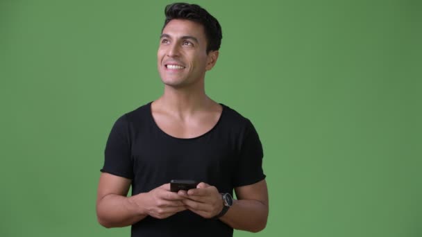 Genç yakışıklı İspanyol adam yeşil bir arka plana dayanır — Stok video