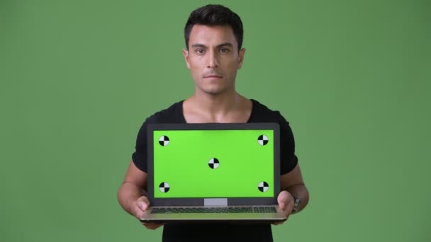 Young handsome Hispanic man against green background — Stock Video