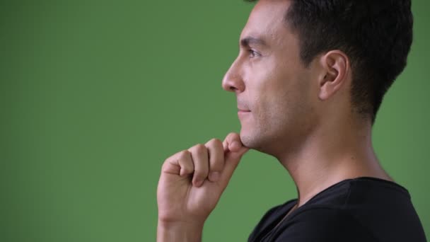 Young handsome Hispanic man against green background — Stock Video