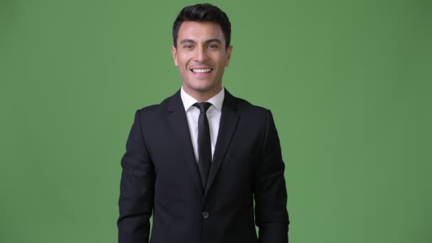 Mladý pohledný podnikatel hispánské proti zeleným pozadím — Stock video