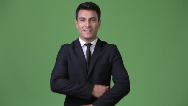 Jovem bonito empresário hispânico contra fundo verde — Vídeo de Stock