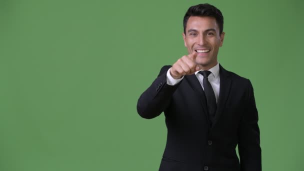 Jonge knappe Hispanic zakenman tegen groene achtergrond — Stockvideo
