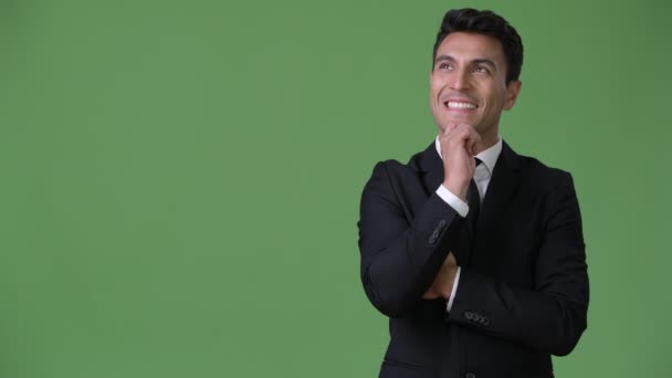 Young handsome Hispanic businessman against green background — Stock Video