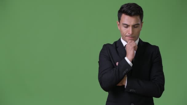 Молодий красивий іспаномовні бізнесмен на зеленому тлі — стокове відео