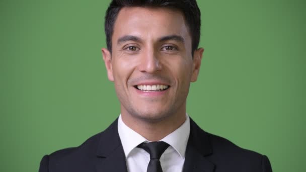 Jovem bonito empresário hispânico contra fundo verde — Vídeo de Stock