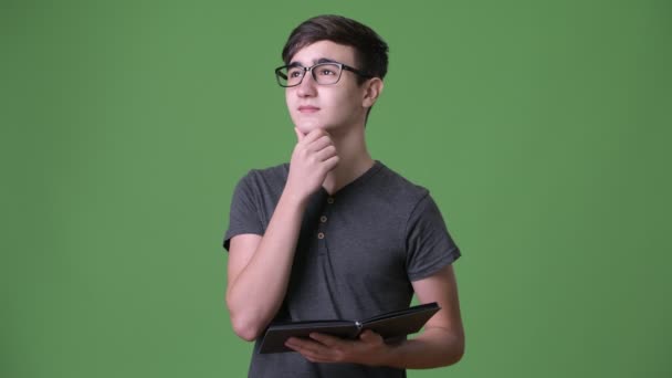 Young handsome Iranian teenage boy against green background — Stock Video