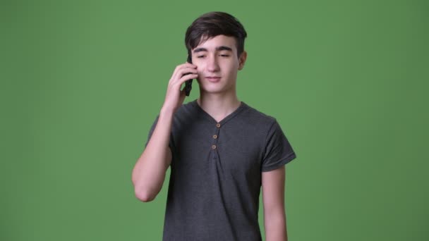 Joven guapo adolescente iraní contra fondo verde — Vídeos de Stock