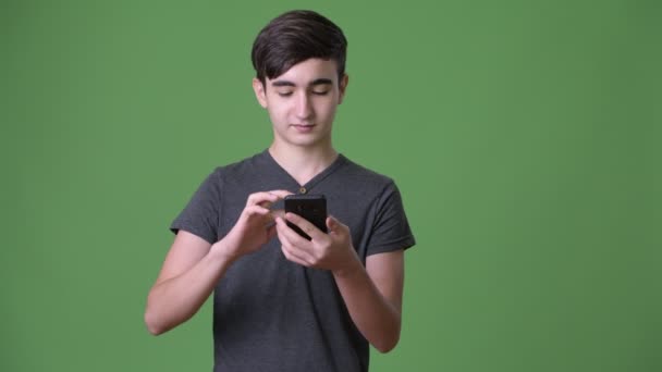 Jovem adolescente iraniano bonito contra fundo verde — Vídeo de Stock