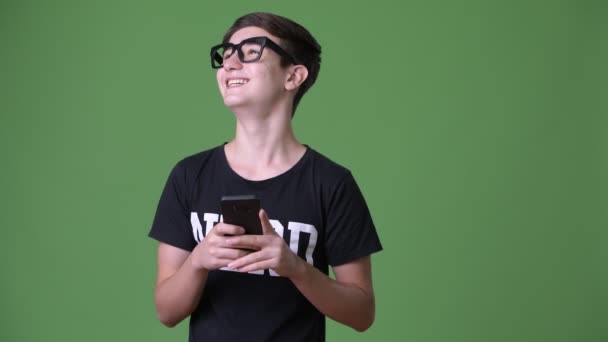 Young handsome Iranian teenage boy against green background — Stock Video