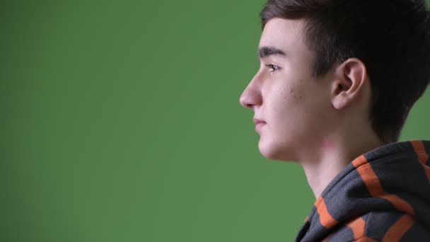 Fiatal jóképű iráni tizenéves fiú zöld háttér — Stock videók