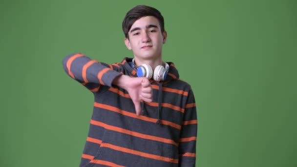Genç yakışıklı İran genç çocuk yeşil bir arka plana dayanır — Stok video