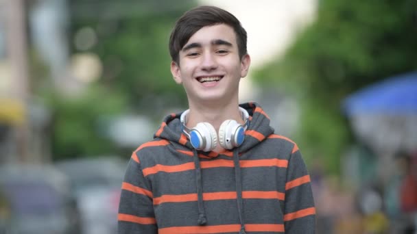 Joven guapo adolescente iraní en las calles al aire libre — Vídeos de Stock