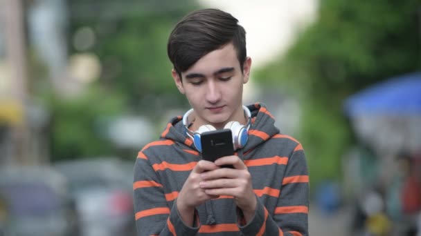 Joven guapo adolescente iraní en las calles al aire libre — Vídeos de Stock