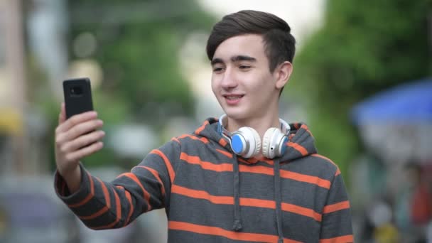 Joven guapo adolescente iraní en las calles al aire libre — Vídeo de stock