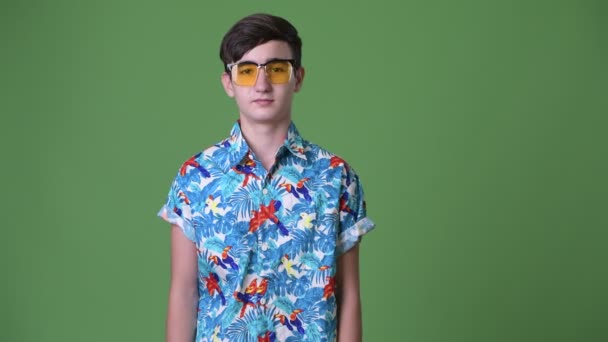Joven guapo adolescente iraní listo para las vacaciones contra el fondo verde — Vídeos de Stock