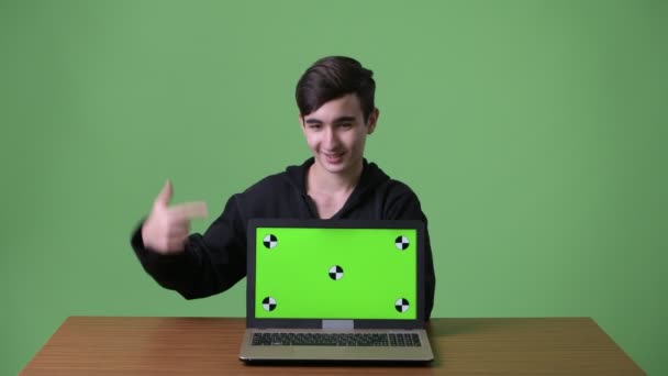 Young handsome Iranian teenage boy against green background — Stock Video