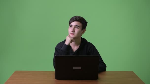 Молодой красивый иранский подросток на зеленом фоне — стоковое видео