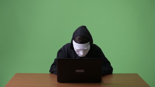 Νεαρό εφηβικό αγόρι υπολογιστή hacker ενάντια σε πράσινο φόντο — Αρχείο Βίντεο